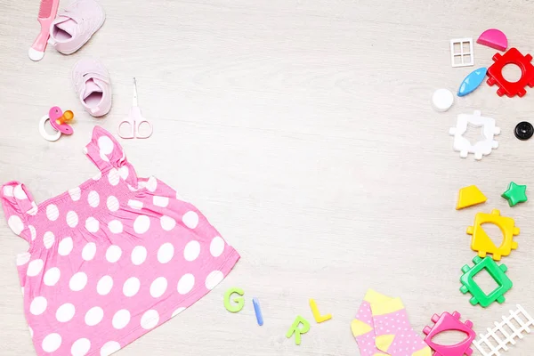 Yerde Plastik Oyuncaklar Olan Bebek Kıyafetleri — Stok fotoğraf