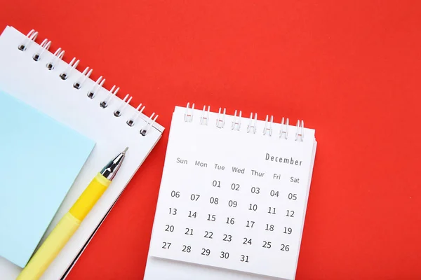Kalenderblatt Mit Notizblock Und Stift Auf Rotem Hintergrund — Stockfoto