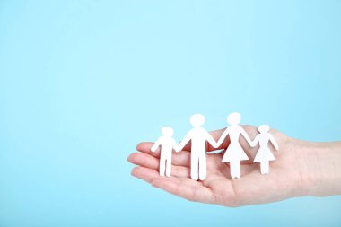 Aile figürleri mavi arka planda kadın elinde