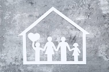 Gri arka planda kalbi olan aile ve ev figürleri