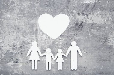 Gri arka planda kalbi olan aile figürleri