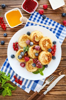 Böğürtlenli krep, reçelli kase ve ahşap masada bal.