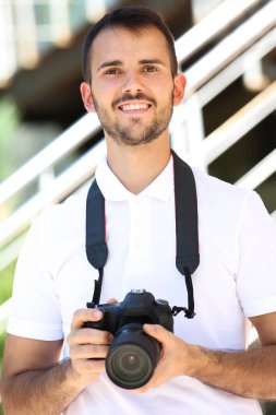 Şehirde kamerası olan genç bir fotoğrafçı.