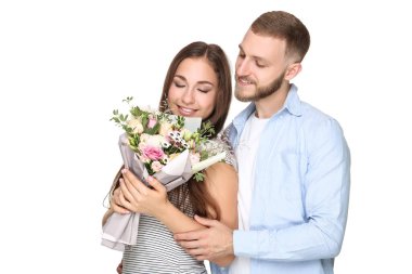 Beyaz arka planda çiçek demeti olan mutlu genç bir çift.