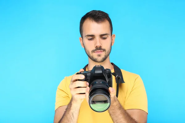 Joven Fotógrafo Con Cámara Sobre Fondo Azul —  Fotos de Stock