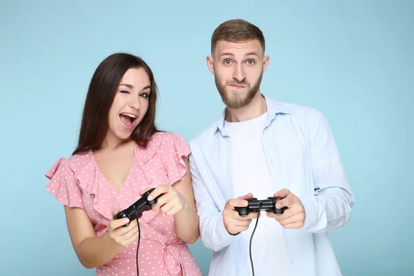 Mavi Arka Planda Joysticklerle Bilgisayar Oyunu Oynayan Mutlu Genç Çift — Stok fotoğraf