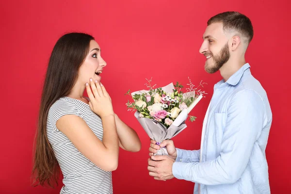 Glad Ung Par Med Bukett Blommor Röd Bakgrund — Stockfoto