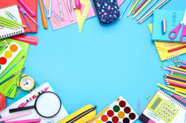 Mavi arka planda farklı okul malzemeleri var.