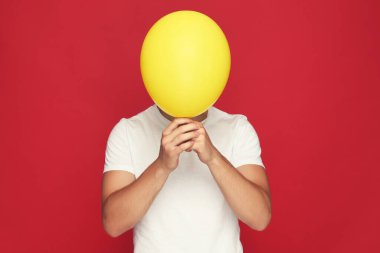 Kırmızı arka planda balonu olan Yuong adamı.