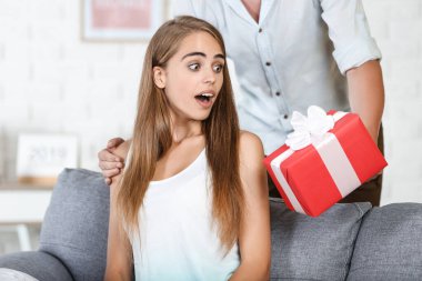 Sürpriz kadın erkek arkadaşından hediye paketi alıyor.