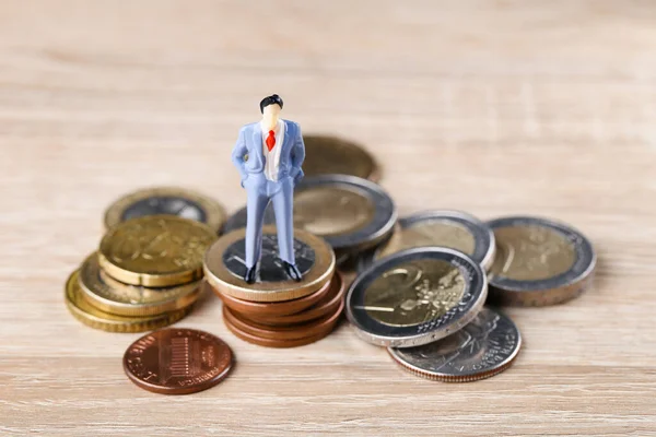 Miniatur Orang Dengan Koin Atas Meja Kayu — Stok Foto