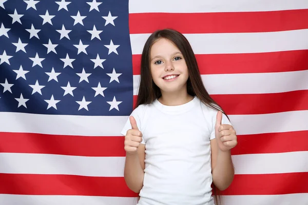 若いです美しいです女の子ショー親指上のアメリカの旗の背景 — ストック写真