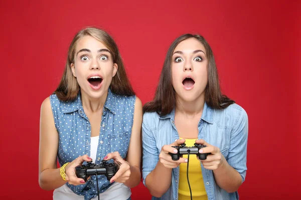 Jong Gelukkig Vriendinnen Spelen Computer Spel Met Joysticks Rode Achtergrond — Stockfoto