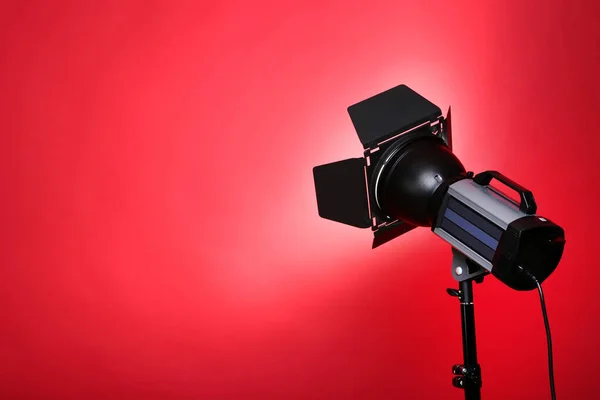 Kırmızı Arkaplanda Ayaklı Stüdyo Işıklandırması — Stok fotoğraf