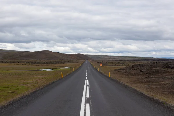 Islandia carretera con montañas en el horizonte Camino recto vacío en el paisaje rural islandés con — Foto de Stock