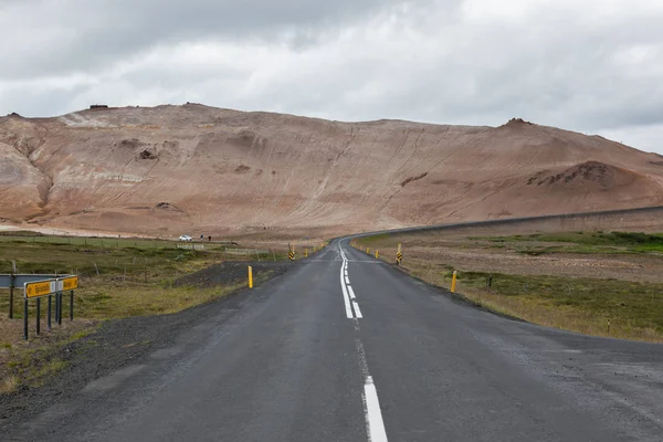 Islandia carretera con montañas marrones en el horizonte Carretera vacía en el paisaje rural islandés Nublado — Foto de Stock