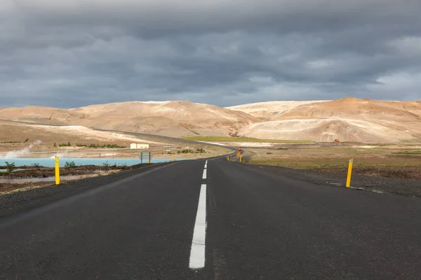 Islandia carretera con montañas marrones en el horizonte Camino vacío en el paisaje rural islandés Lago cerca — Foto de Stock