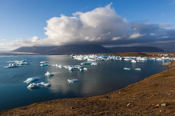 Iceberg dispersi vicino alla riva della laguna del ghiacciaio di Jokulsarlon Riscaldamento globale e cambiamento climatico — Foto Stock