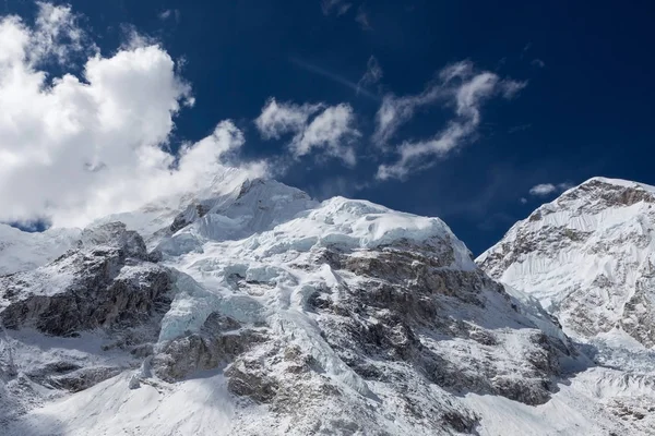 Wunderschöner schnee- und eisbedeckter Bergblick auf die Gipfel und blauer Himmel mit weißen Wolken von — Stockfoto
