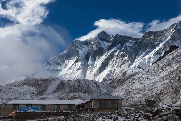 Mountain house in snow under Lhotse mountain vertical wall Fascinating photo