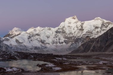 Cholatse Dağı 'nın dramatik karlı zirvesi Moraine Gölleri bölgesinin üzerinde yükseliyor.