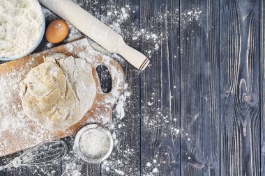 Hamur Hazırlık ekmek, pizza, yemek düz mutfak masasının üstünde yatıyordu. Un, yumurta, Kuru üzüm, tohum veya pişirme ile çalışma.