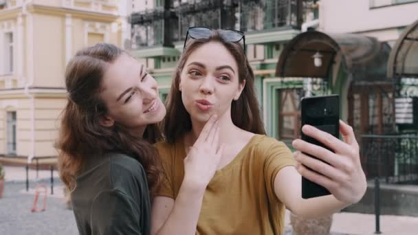 Duas meninas amigo fazendo selfie usando telefone com emoções diferentes — Vídeo de Stock