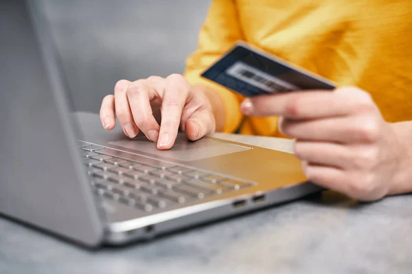 Un colpo ravvicinato di carta di credito in mano alla donna. Shopping online da casa Immagine Stock