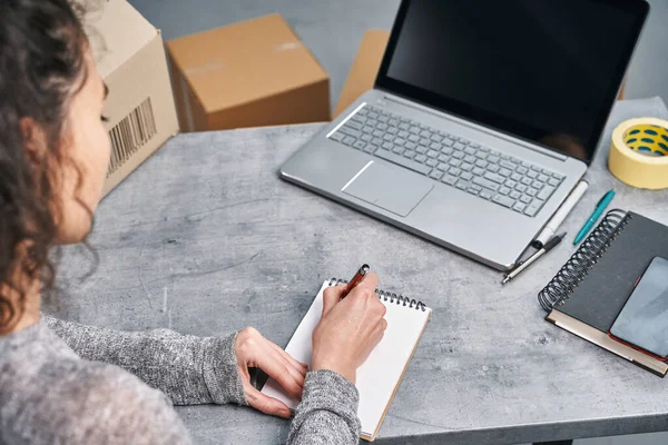 Woman sending parcel using her laptop. Working from home — Stock Photo, Image