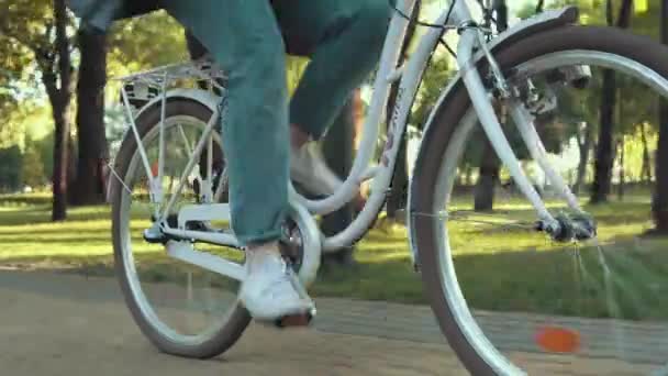 Primer plano de la mujer montar en bicicleta de la ciudad en el parque en la mañana soleada — Vídeos de Stock