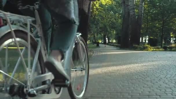 Primer plano de la mujer montar en bicicleta de la ciudad en el parque en la mañana soleada — Vídeo de stock