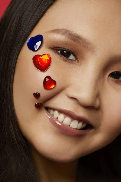 Asian woman with hearts on her face