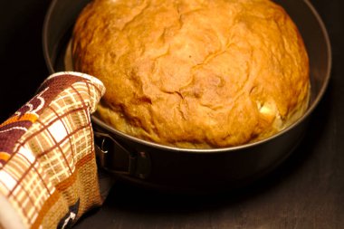  Karanlık bir arka plan üzerinde yuvarlak bir pişirme çanağı içinde ev yapımı taze pişmiş ekmek