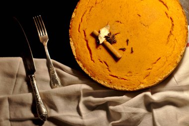 Karanlık masada kabak pasta yuvarlak altın