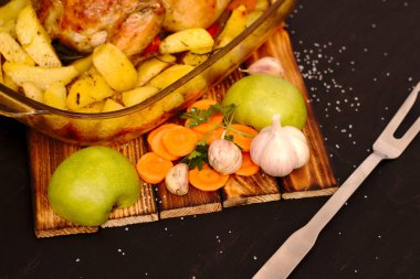 fırında pişmiş elma tavuk bir ahşap tahta üzerinde bir cam tabak