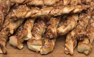 siyah zemin ahşap bir gemide jambon ve susam tohumu ile bükülmüş peynir ekmek sopa