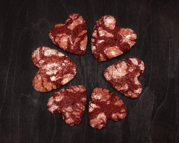 red chocolate cracked heart-shaped cookies on on a dark background. A gift for Valentine's Day, World Women's Day or Birthday