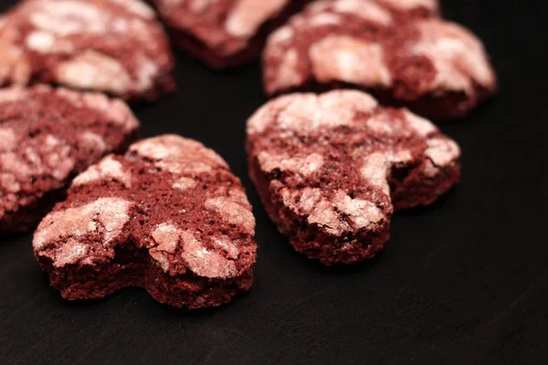 red chocolate cracked heart-shaped cookies on on a dark background. A gift for Valentine's Day, World Women's Day or Birthday