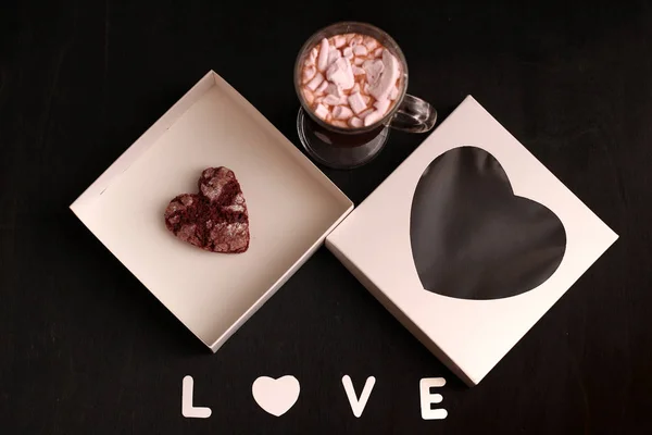 Hot drink in a glass cup with pink marshmallows and white box with a transparent cover in the form of heart with cookies — Stock Photo, Image