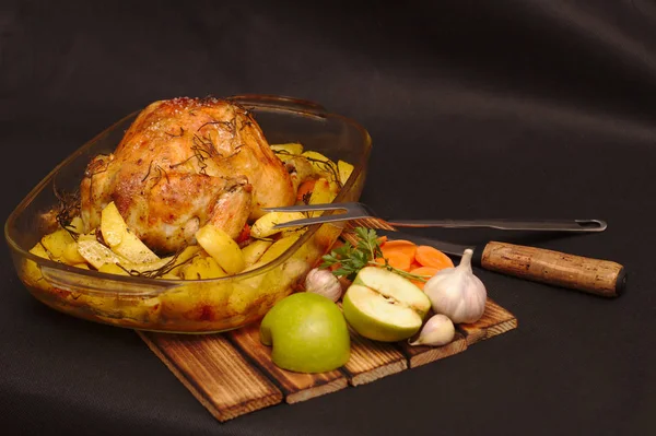 oven-baked crispy crust stuffed chicken on a plate with potatoes and apples
