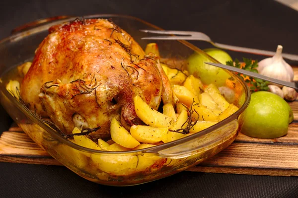 Corteza crujiente al horno de pollo relleno en un plato con patatas y manzanas —  Fotos de Stock