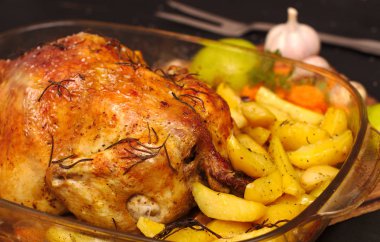 fırında pişmiş gevrek kabuk patates, elma, sarımsak ile bir plaka üzerinde tavuk doldurulmuş