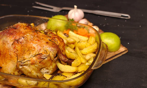 Al horno crujiente corteza de pollo relleno en un plato con patatas, manzanas, ajo —  Fotos de Stock
