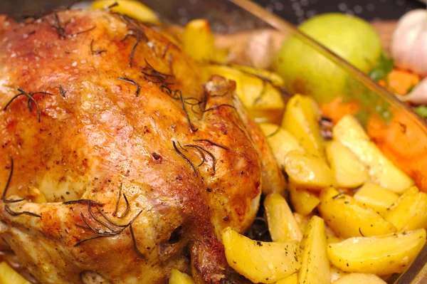 Al horno crujiente corteza de pollo relleno en un plato con patatas, manzanas, ajo —  Fotos de Stock