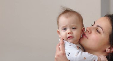 Genç Anne kollarına onu komik, tatlı bebek tutar