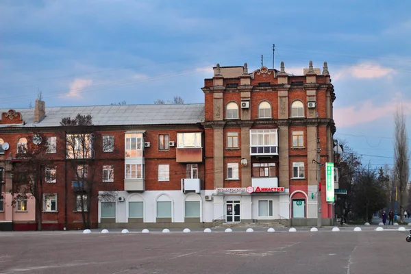 O edifício na praça central em Severodonetsk, região de Luhansk, Ucrânia. Pôr-do-sol da paisagem urbana da noite . — Fotografia de Stock