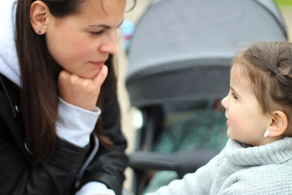 sokakta bir yürüyüş annesi ile güzel küçük neşeli gülümseyen kız