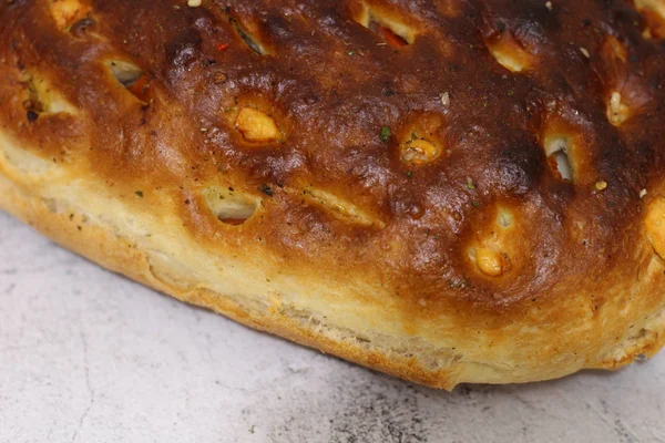 Pane italiano con formaggio, pomodori ed erbe aromatiche. Focaccia sul tavolo . — Foto Stock