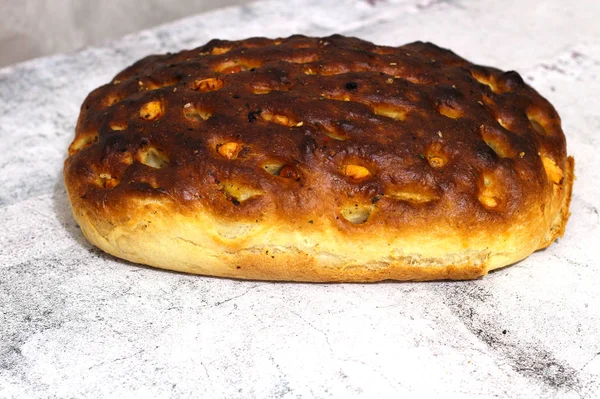 Olasz kenyér sajttal, paradicsommal és gyógynövényekkel. Focaccia az asztalra. — Stock Fotó