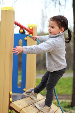 bir çocuk oyun alanında bir ip tırmanıyor